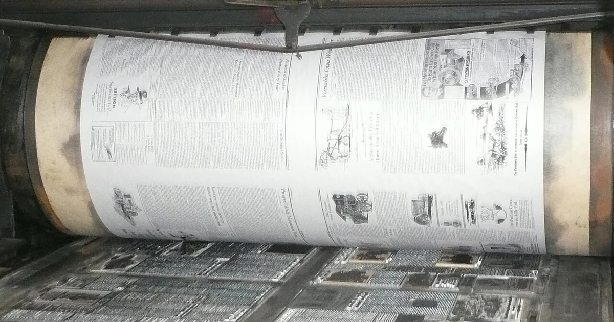 The bed of metal type and print roller of a Miehle Model 00 flat-bed cylinder printing press in operation. This press, now at the printer's hall of the Old Thresher's Reunion museum, was originally sold to the US Bureau of Engraving and Pri